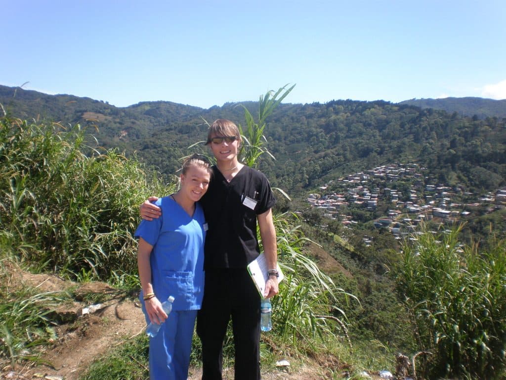 Drs. Justin and Christie Smith in scrubs overlooking a valley on the Costa Rica medical mission trip where they met