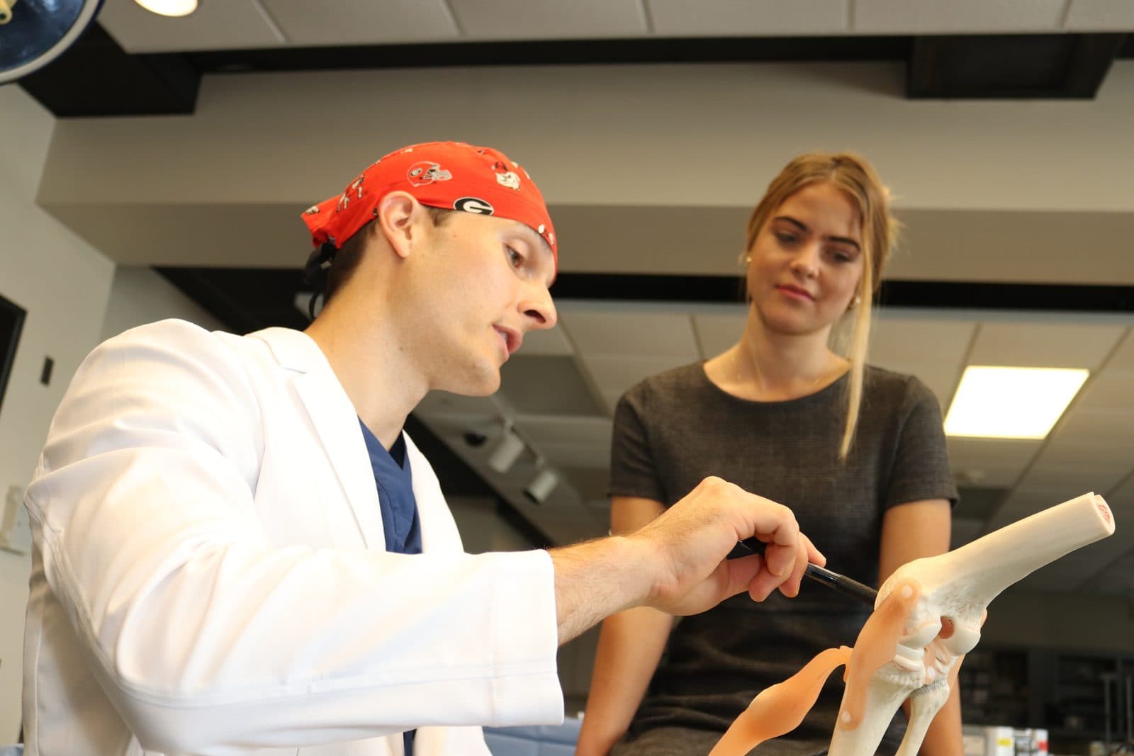 Dr. Smith walking a patient through a knee model during a consultation